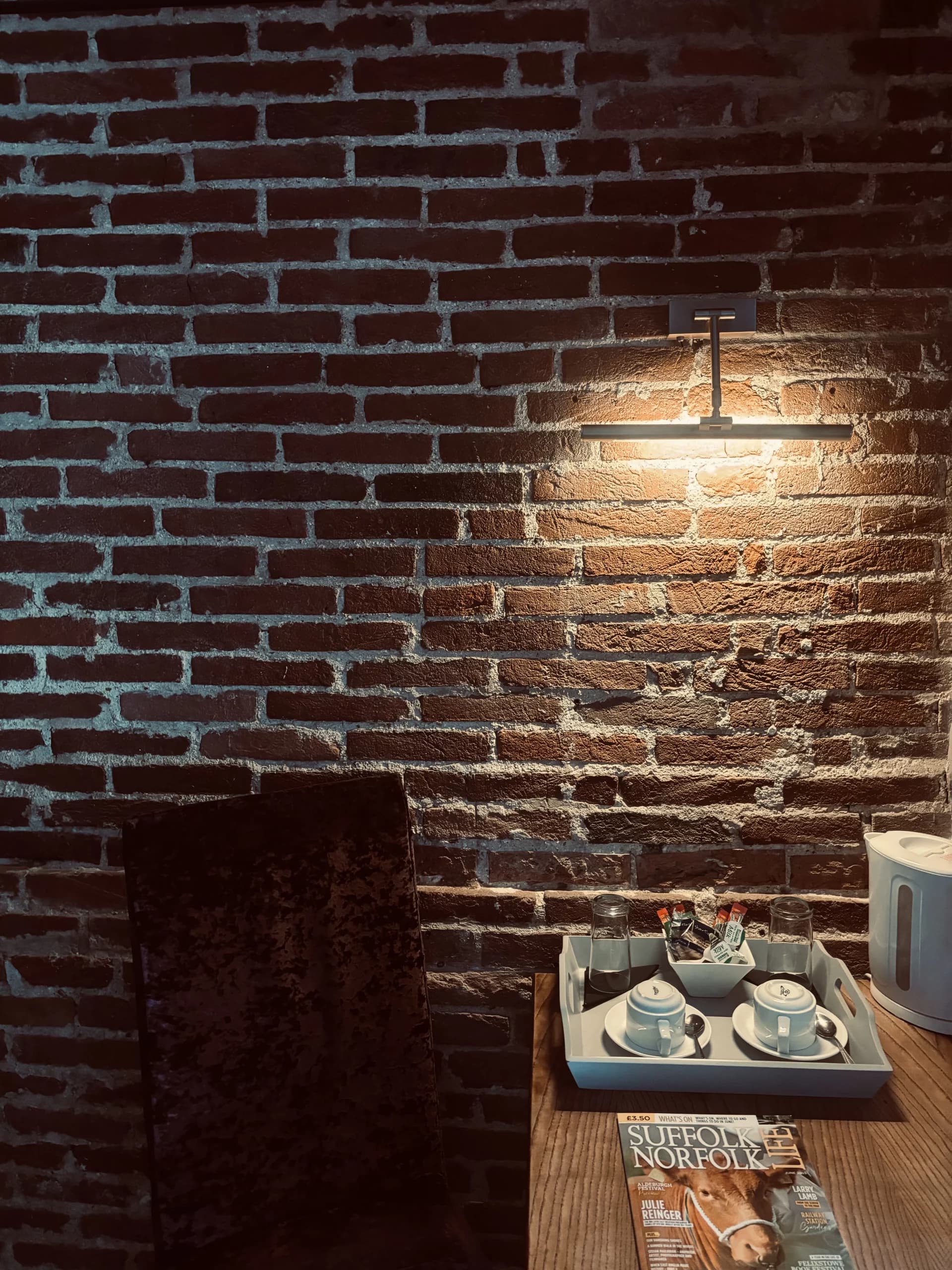 Room detail — tea tray and kettle against an exposed brick wall